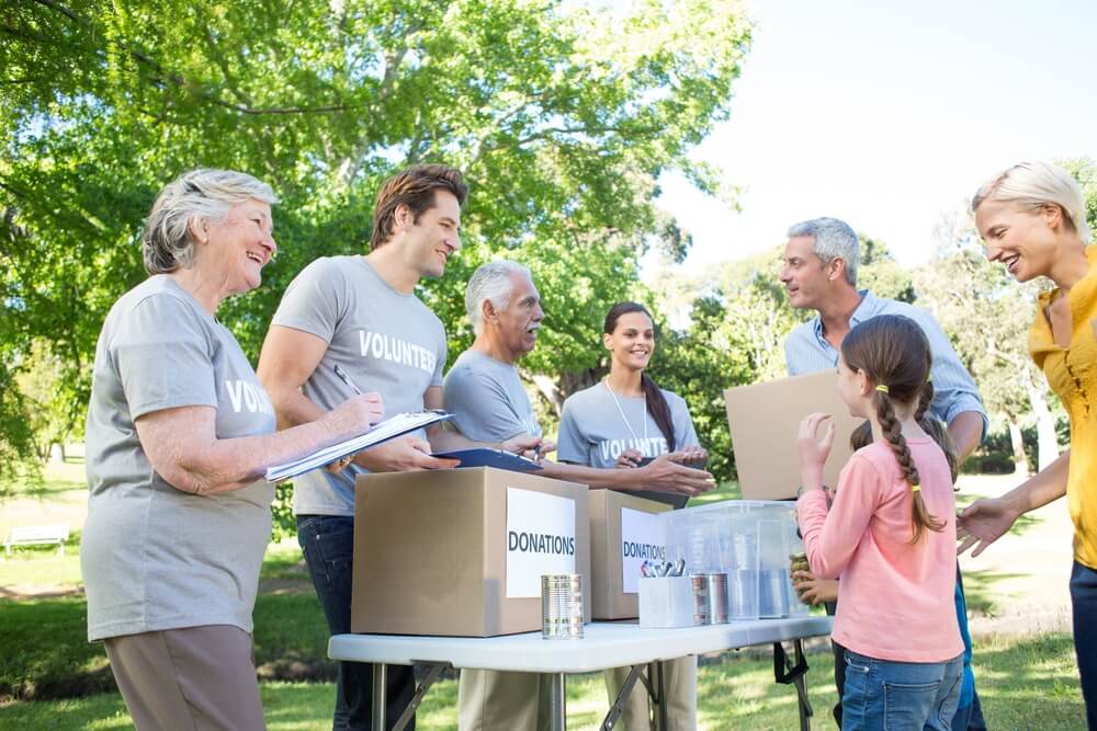 Happy volunteer family separating donations stuffs on a sunny day