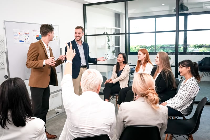 Marketing team gathers around their manager for a training session