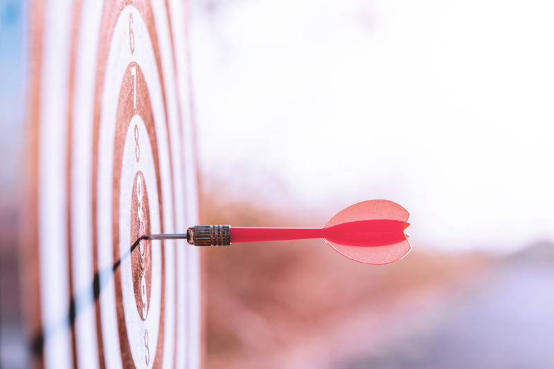 Close up photo of dart landing perfectly on target