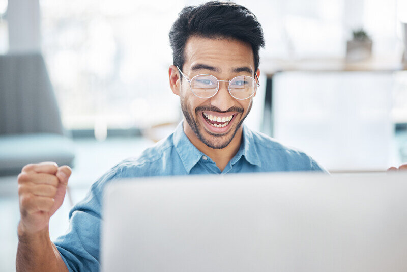 Worker clenches fight with joy as he finds success on a computer