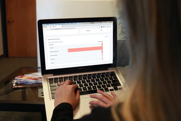 Woman on laptop looking at contacts by lifecycle stage