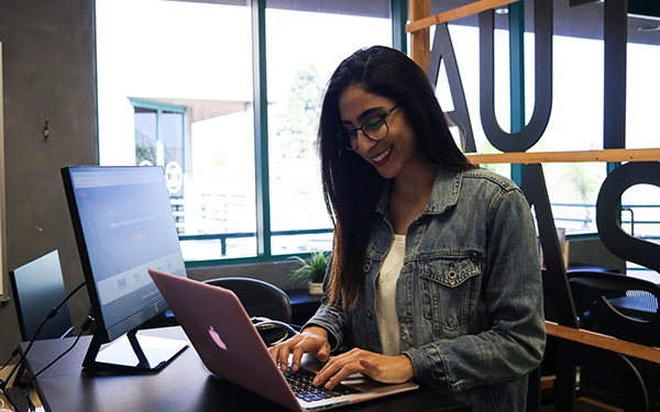 Girl smiling while using laptop