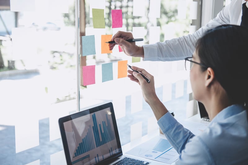 Workers plan out content schedule by a computer