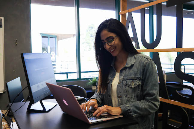 Elika smiling at laptop