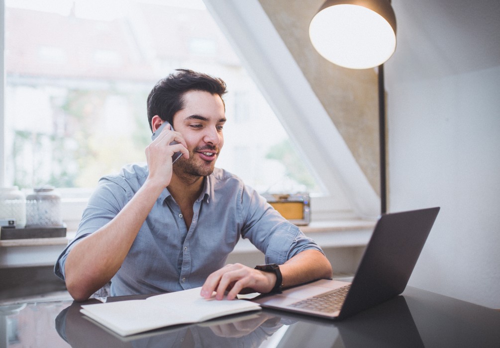 young-man-is-having-conversation-on-the-phone-while-checking-his-email-account_t20_09ERww